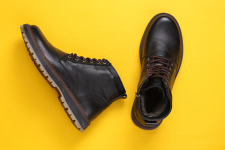 Men's leather boots on yellow background