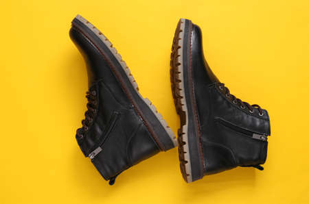 Men's leather boots on yellow background