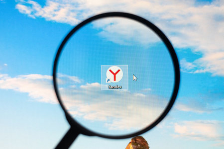 Odessa, Ukraine - December 17, 2020: Yandex shortcut on desktop screen through magnifying glassのeditorial素材