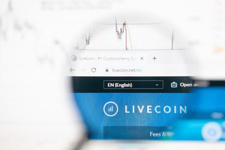 Odessa, Ukraine - December 17, 2020: Livecoin.net cryptocurrency website on monitor screen under magnifying glass.のeditorial素材