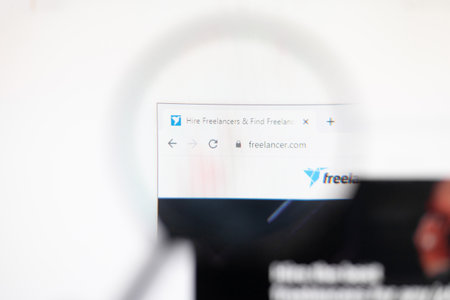 Odessa, Ukraine - December 17, 2020: Freelancer.com website on monitor screen under magnifying glass.のeditorial素材
