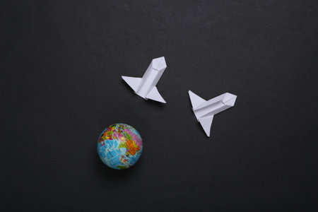 Origami space rocket shuttle and globe on black background. Space flight concept. minimalismの写真素材