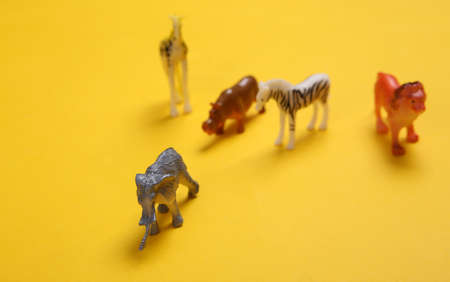 Toy wild animals on yellow background. Save animals concept.の写真素材