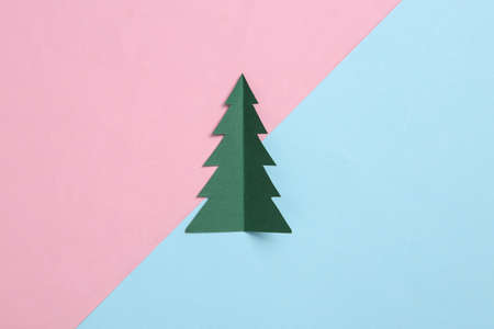Paper cut christmas tree on blue pink pastel backgroundの写真素材
