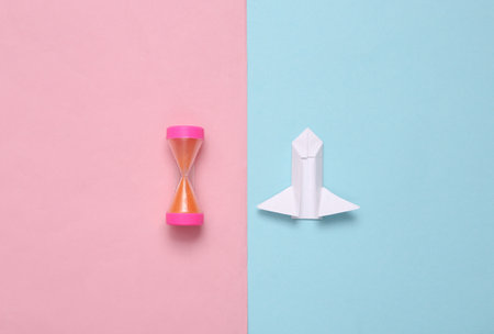 Paper space shuttle and hourglass on pink-blue background. Conquest of space concept