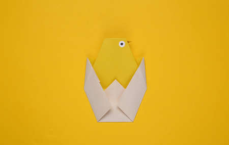 Origami chicken on a yellow background