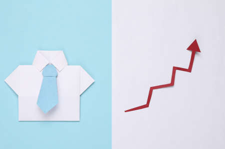 Origami paper shirt with tie, growth arrow on blue white background. Economics, Business and Finance conceptsの写真素材