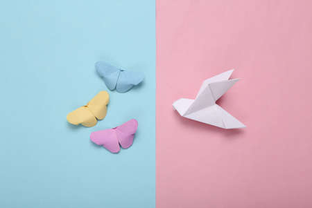 Composition of origami butterflies and dove on blue pink pastel background