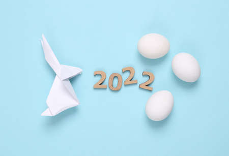 Origami easter bunny, eggs and 2022 on blue background. Easter 2022の写真素材