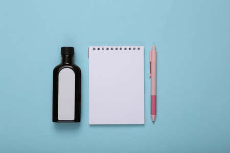 Cough bottle syrup and notebook on blue backgroundの写真素材