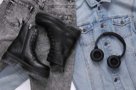 Leather black boots and headphones on jeansの写真素材