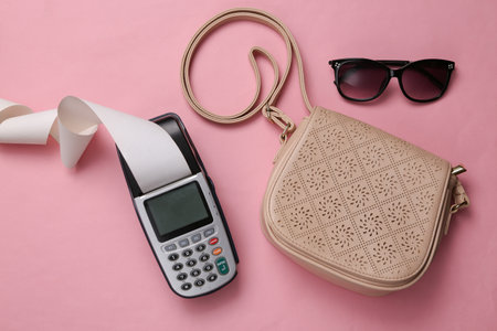 Payment terminal with sunglasses, bag on a pink background. shopping, payment for purchases