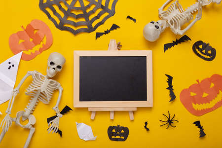 Mini blank chalk board with copy space and halloween decor on yellow background. Trick or treat. flat layの写真素材
