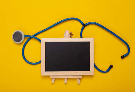 Mini Empty chalk board with copy space and stethoscope on yellow background. medicine conceptの写真素材