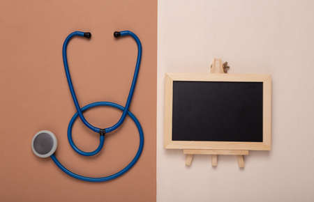 Mini Empty chalk board with copy space and stethoscope on brown beige background. medicine conceptの写真素材