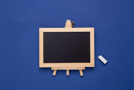 Mini blackboard with chalk on blue background. Empty, blank chalkboard with copy space. Business, education, learning concept.の写真素材