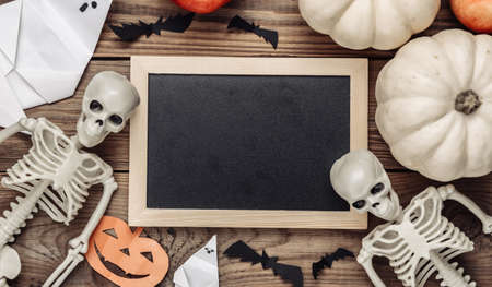 Mini blank chalk board with copy space and halloween decor on wooden table. Trick or treat. flat layの写真素材