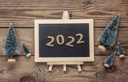 Mini blackboard with Christmas tree, 2022 on wooden table. New year, Christmas still lifeの写真素材