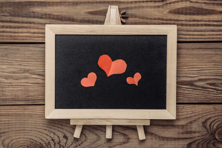 Chalk board with hearts on a wooden table. valentines day concept