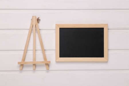 Mini blank chalk board and tripod on white wooden tableの写真素材