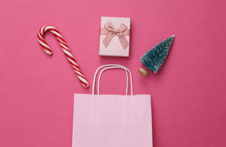 Christmas shopping. Christmas accessories and shopping bag on a pink background. top view. flat lay compositionの写真素材