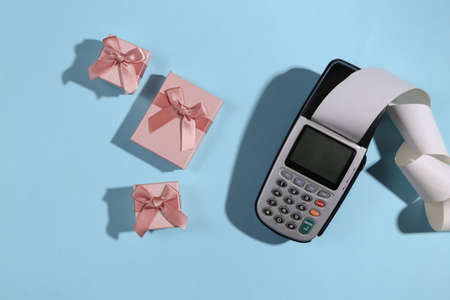 Payment terminal and gift boxes on blue bright background. Christmas shopping. top viewの写真素材