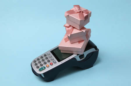 Payment terminal with gift boxes on blue background.の写真素材