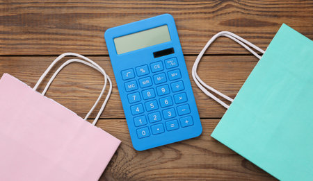 Paper shopping bag and calculator on wooden table. top viewの写真素材