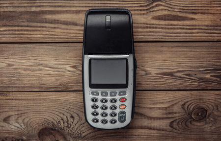 Payment POS terminal on wooden table. top view