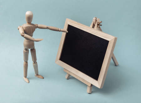 Mini chalk board and wooden puppet on a blue background. Learning, business, education, school conceptの写真素材