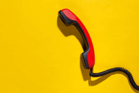 Retro cable phone tube on yellow bright background. copy spaceの写真素材