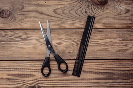 Scissors and hairbrush on wooden table. Set for haircuts, hair care, barbershopの写真素材