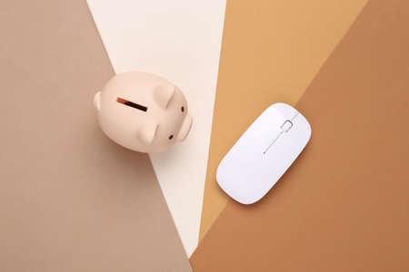 Piggy bank and pc mouse on a colored background. online investment
