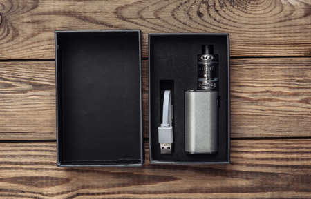 New vaping device in a box on wooden tableの写真素材