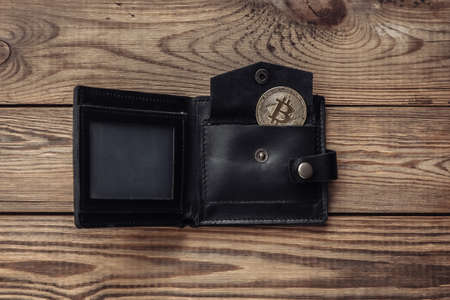Bitcoin and wallet on wooden table. Cryptocurrencyの写真素材