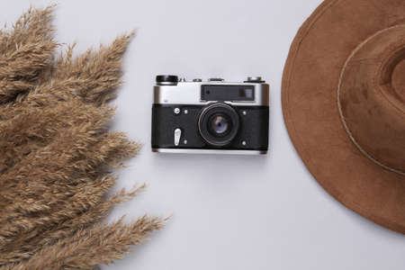 autumn creative composition. Beige reeds branches bouquet, hat and camera on white background. travel concept. flat layの写真素材