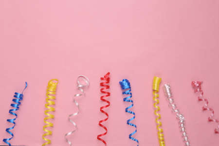Colored serpentine on a pink background. Holiday, birthday background. copy spaceの写真素材