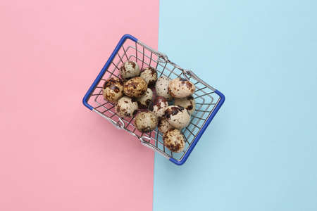 Shopping basket with quail eggs on pink blue backgroundの写真素材