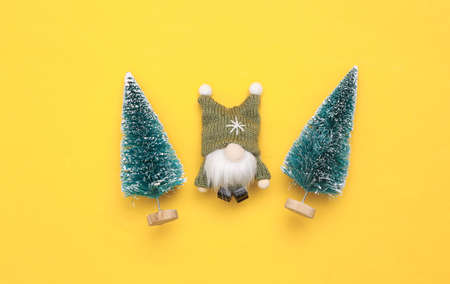 Christmas elphs and Christmas trees on yellow background. top viewの写真素材