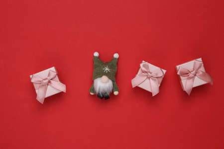 christmas composition. Christmas gnome and gift boxes on a red backgroundの写真素材