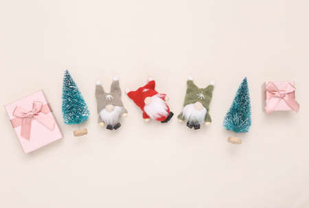 Christmas gnomes, gift boxes and Christmas trees on beige background. top viewの写真素材