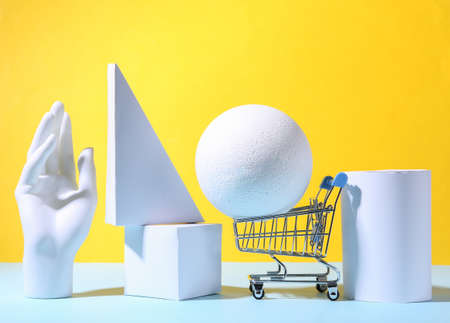Concept art geometric composition of geometric shapes and shopping trolley on a blue yellow background. minimalism. sale. showcaseの写真素材