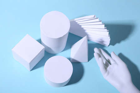Basic geometric shapes and hand against blue bright background with shadow. minimalismの写真素材