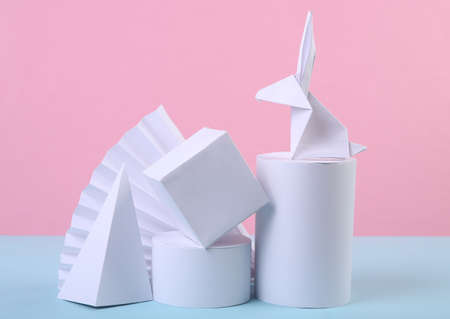 Easter minimalistic composition of origami bunny and geometric shapes on blue pink pastel background. concept artの写真素材