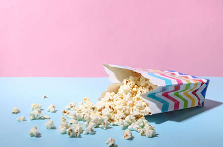Bucket of sprinkled popcorn on blue pink pastel backgroundの写真素材