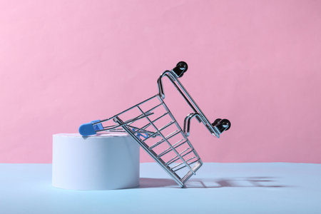 Mini shopping cart and podium on blue pink pastel backgroundの写真素材