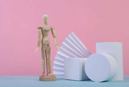 Wooden puppet and geometric shapes on blue pink pastel background. Abstract background, concept art, minimalism. geometric compositionの写真素材