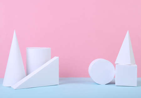 White geometric shapes on a blue-pink pastel background. Composition of different geometric objects....