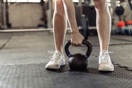Woman's hand holding a heavy kettlebell in the gymの写真素材