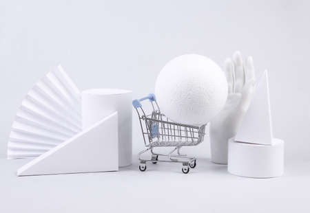 Geometric shapes and shopping trolley on white background. minimalism. sale. showcase